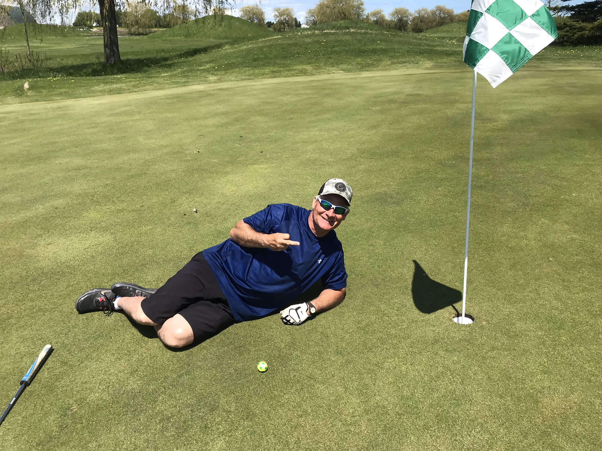 Bryan laying next to his golf ball during a round