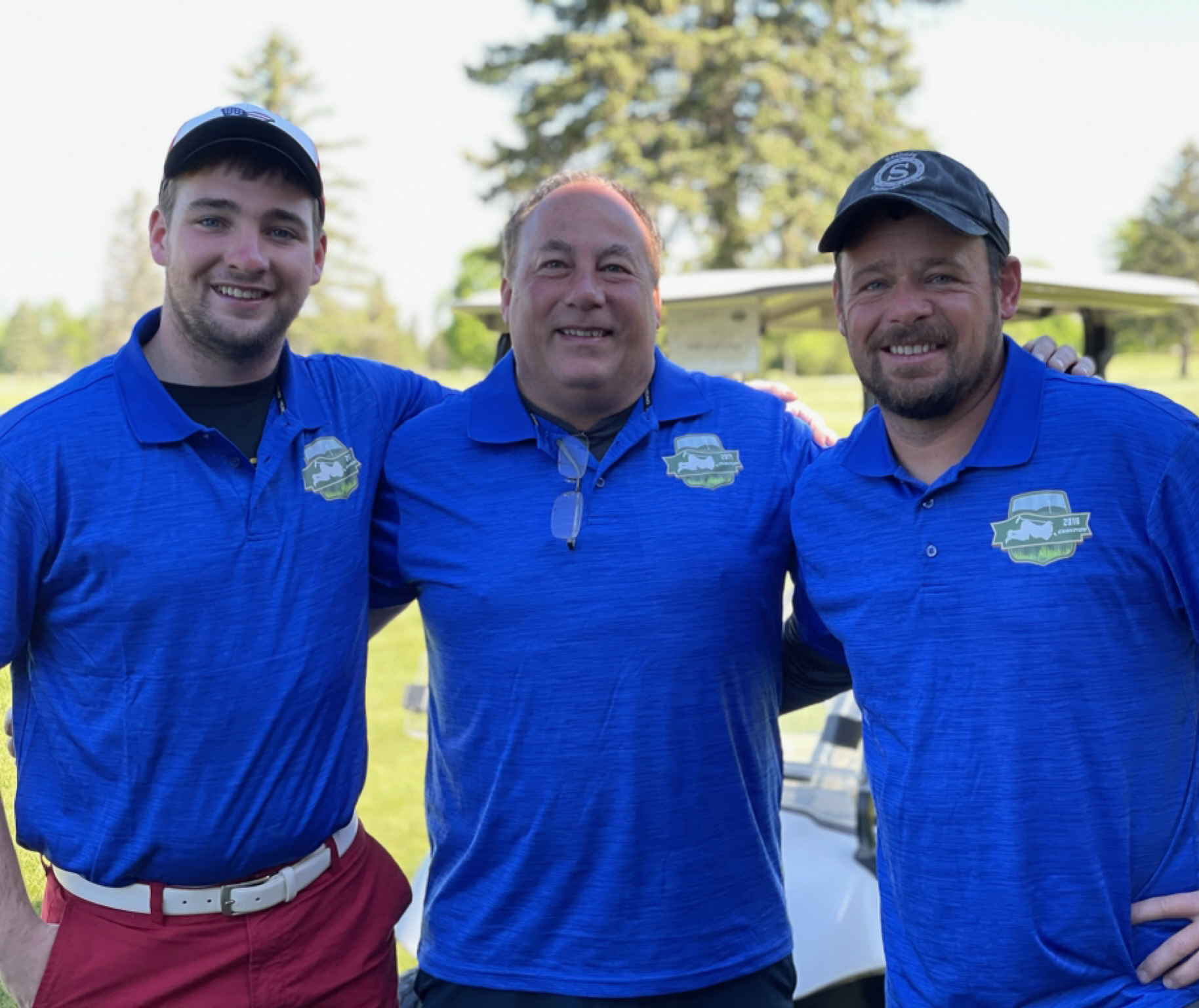 Champions wearing blue polos after the 2021 event